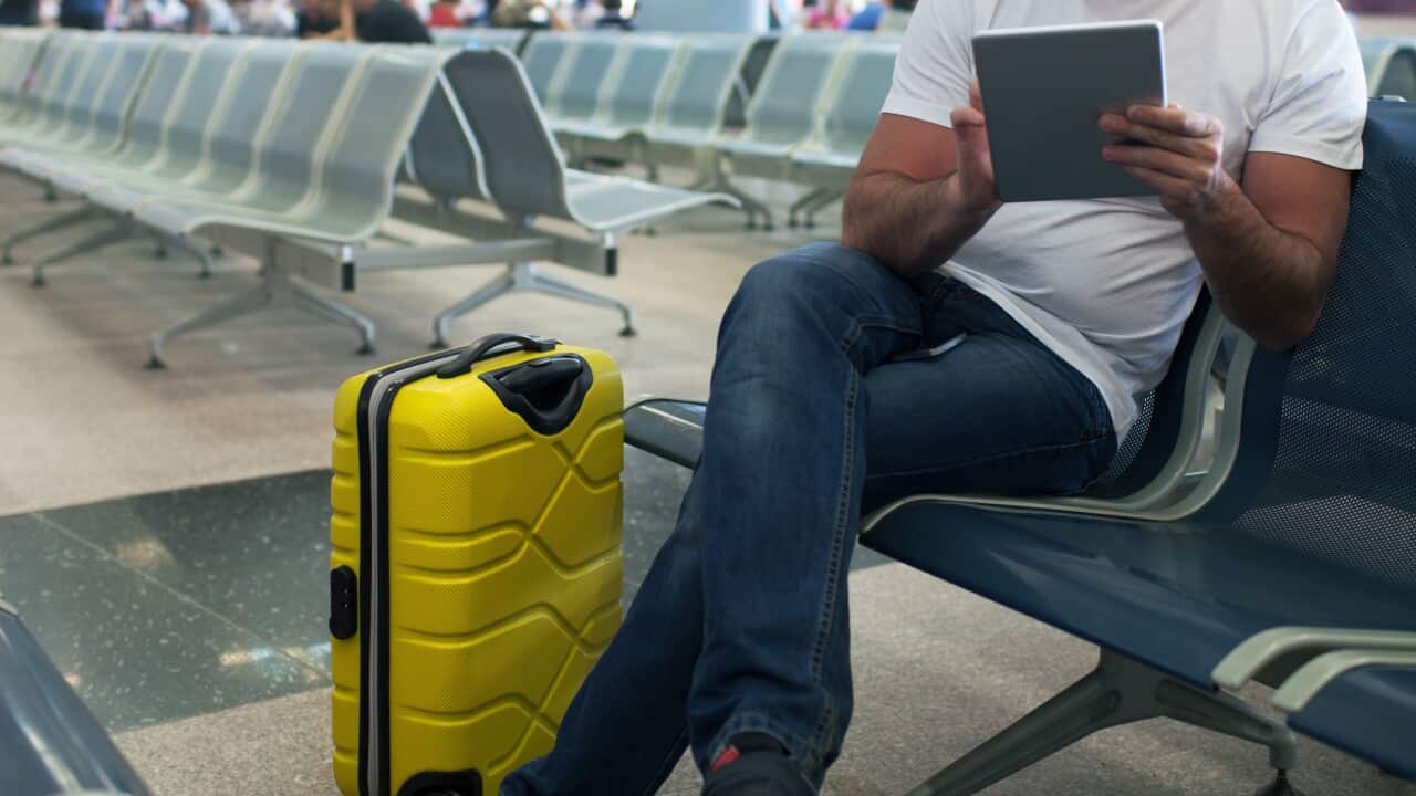 Young man using touch pad in the airport lounge