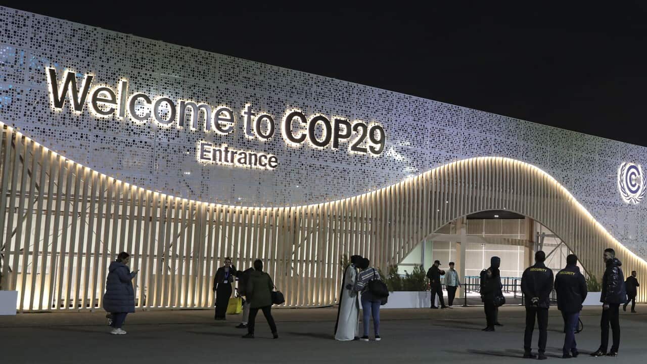 Participants and security staff stand outside the venue of the United Nations Climate Change Conference COP29 in Baku, Azerbaijan, 16 November 2024