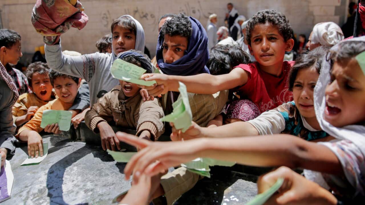 Yemenis present documents in order to receive food rations
