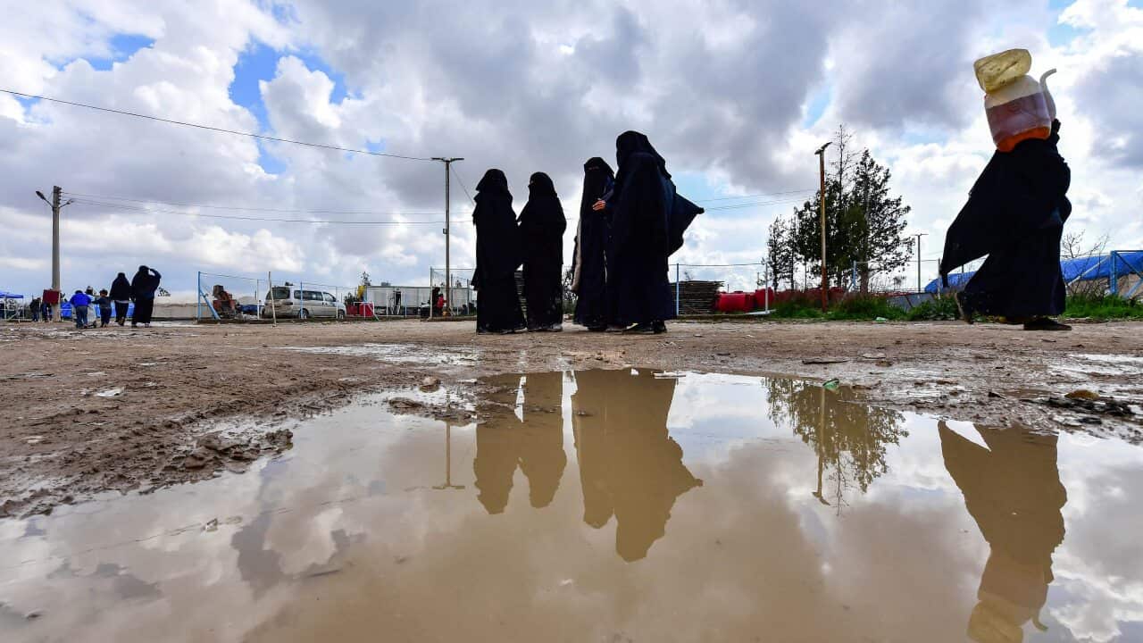 Women living inside Al-Hawl camp which houses relatives of Islamic State group members, walk inside the site in al-Hasakeh governorate in northeastern Syria.