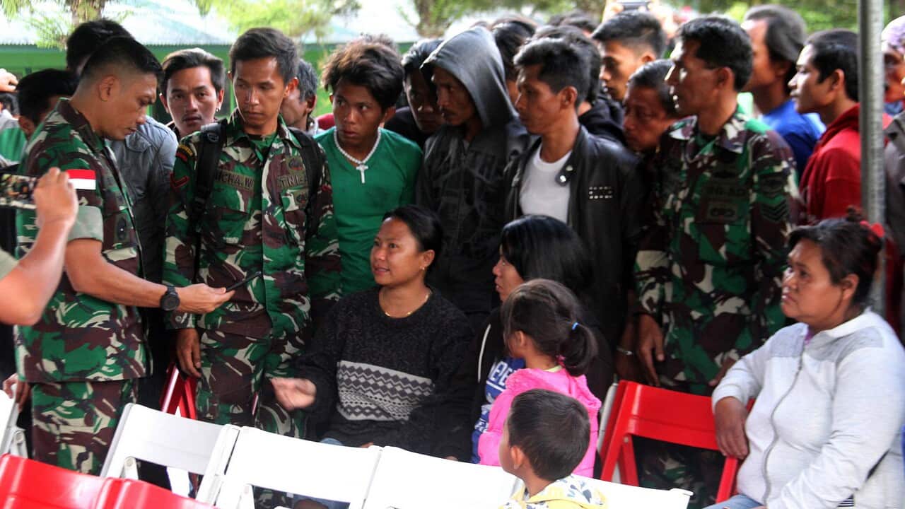 Indonesian military personnel listen to the relatives of construction workers, who were shot dead by suspected separatists, in Wamena, Papua.