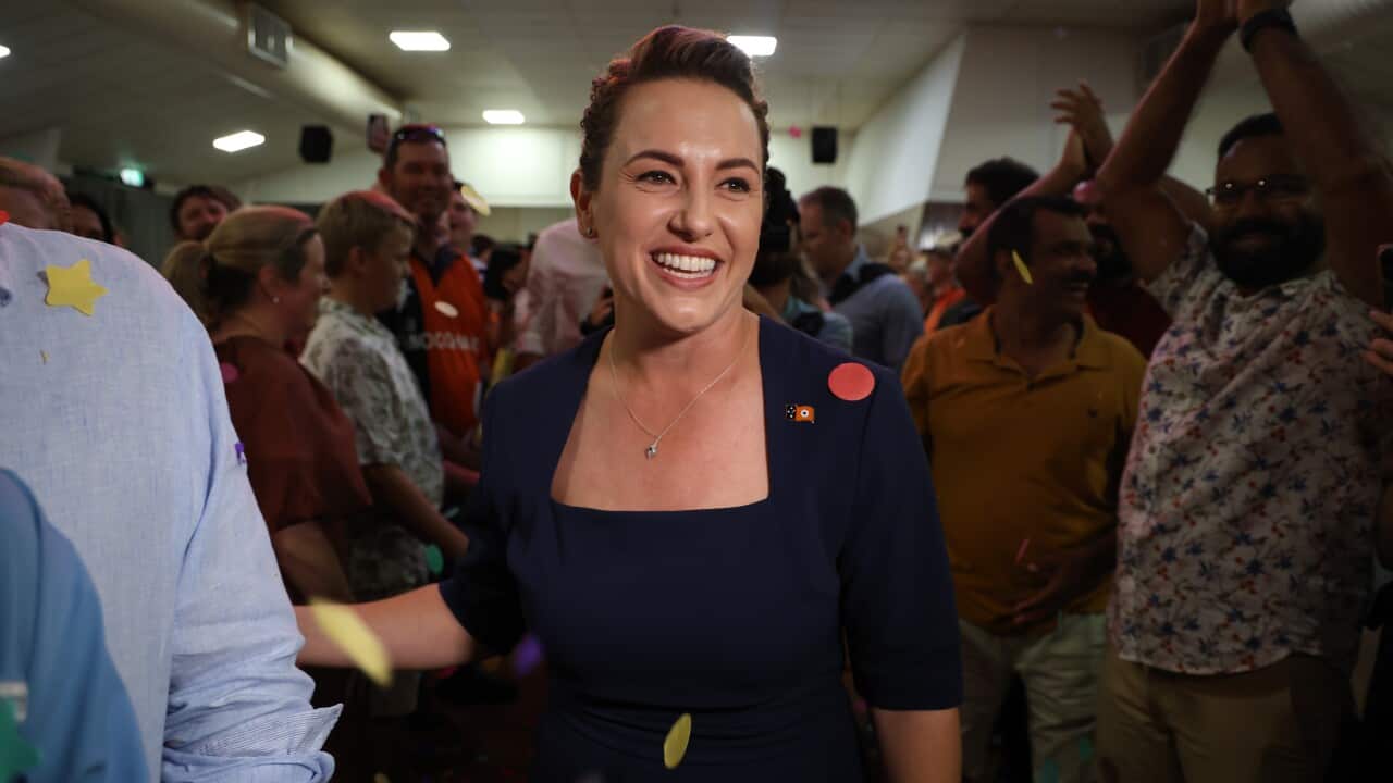 A woman smiles amid her rejoicing supporters