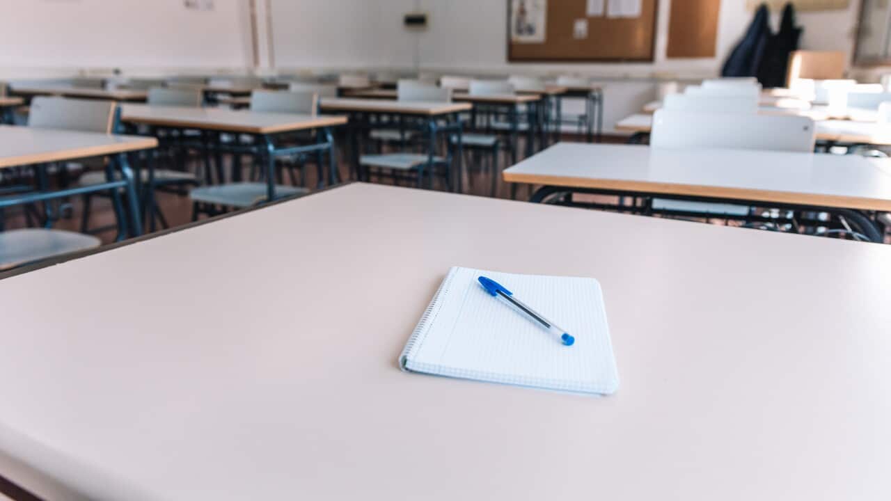 Notebook with a pen on a table in a classroom at a school