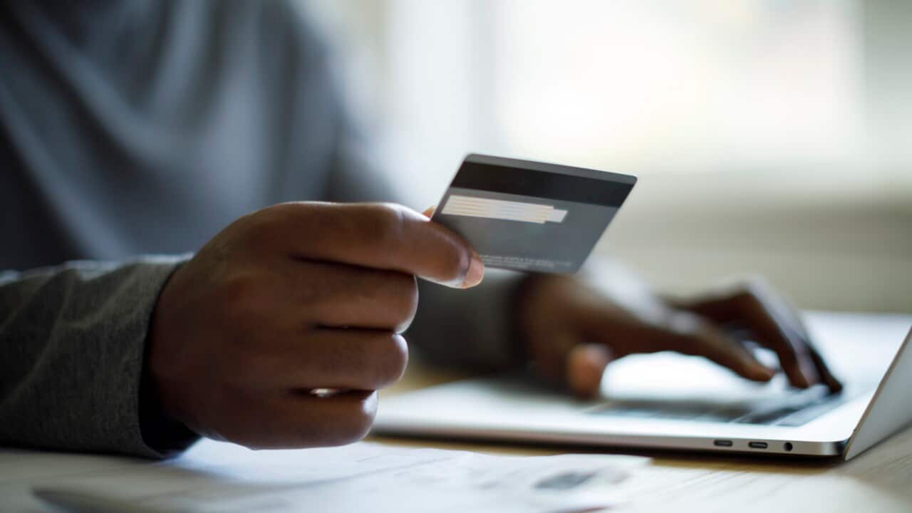 Close up shot of man using credit card and laptop