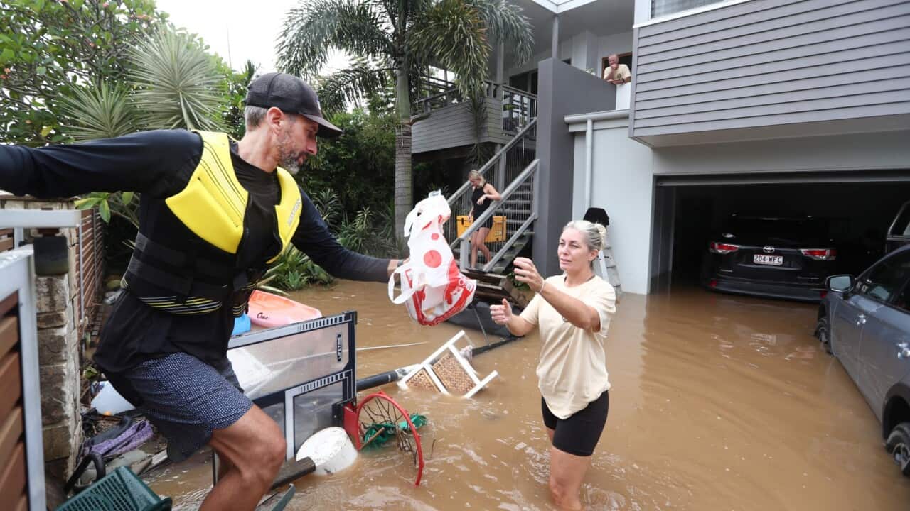 Volunteer and Kingscliff resident Dave Prince hands over some supplies to flooded resident Kirri Henry in Fingal, Northern NSW, Tuesday, March 1, 2022.