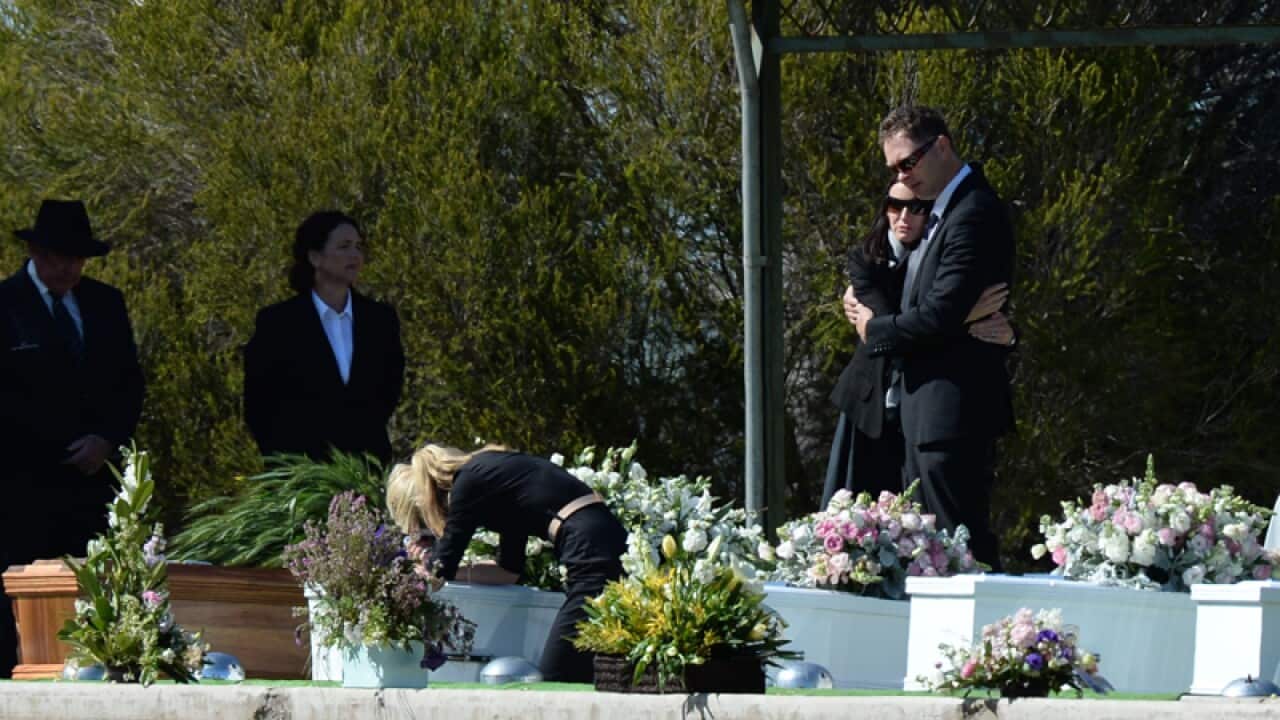 Mourners attend the burial service for the Hunt family