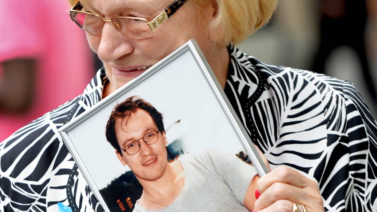 Paula Braut with a photograph of her son Patrice