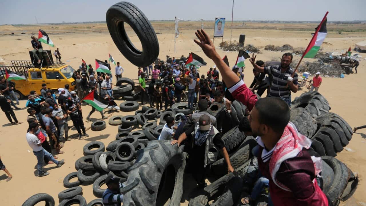 Palestinian protesters take part during clashes with Israeli soldiers at the border fence with Israel east of Khan Yunis in the southern Gaza Strip