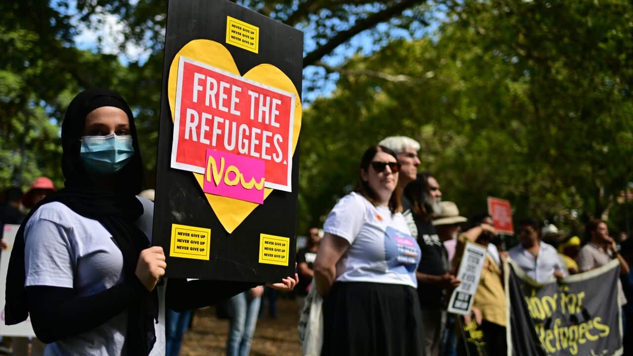 Protesters are seen holding placards calling for the release of refugees.