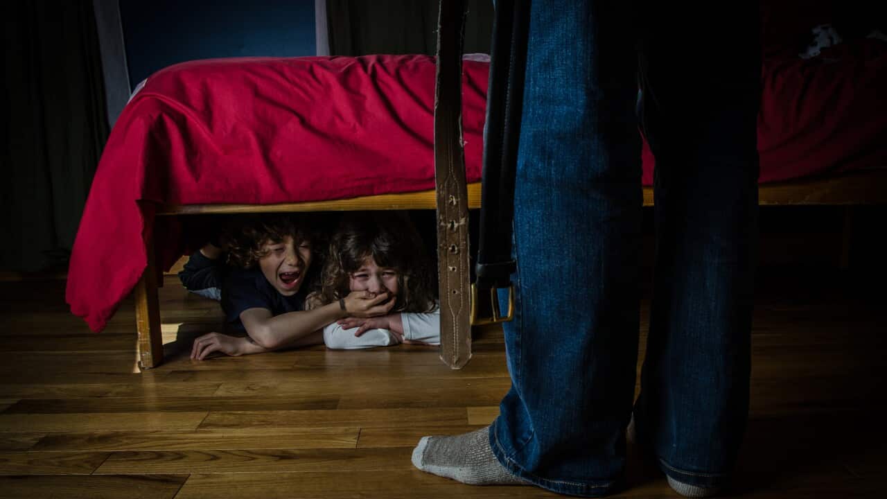 Two kids hidden under bed crying out of fear