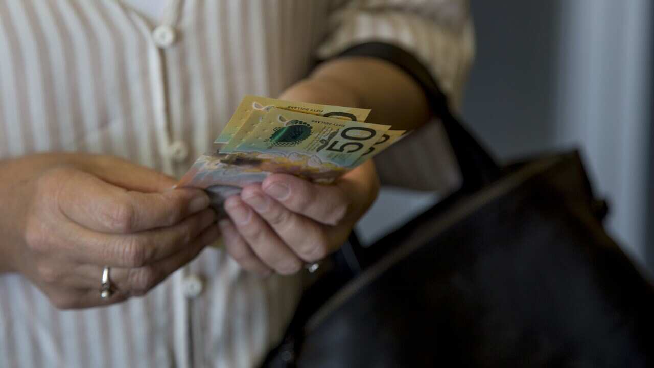 A lady holding Australian currency