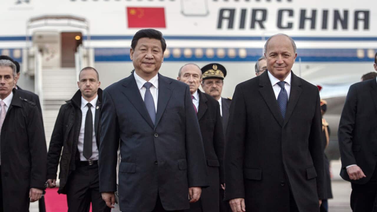 China's President Xi Jinping (C) arrives in France