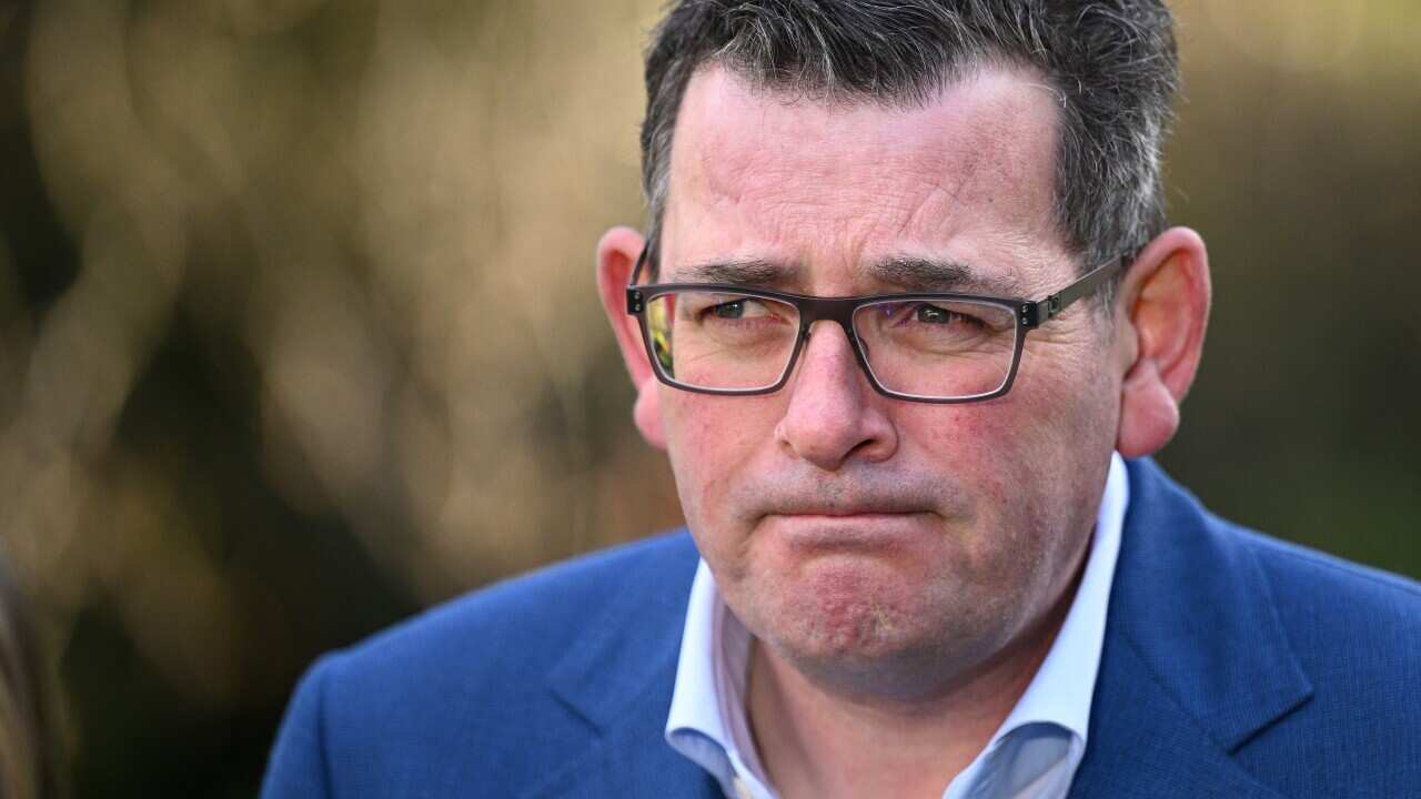A man wearing a suit and glasses standing outside.