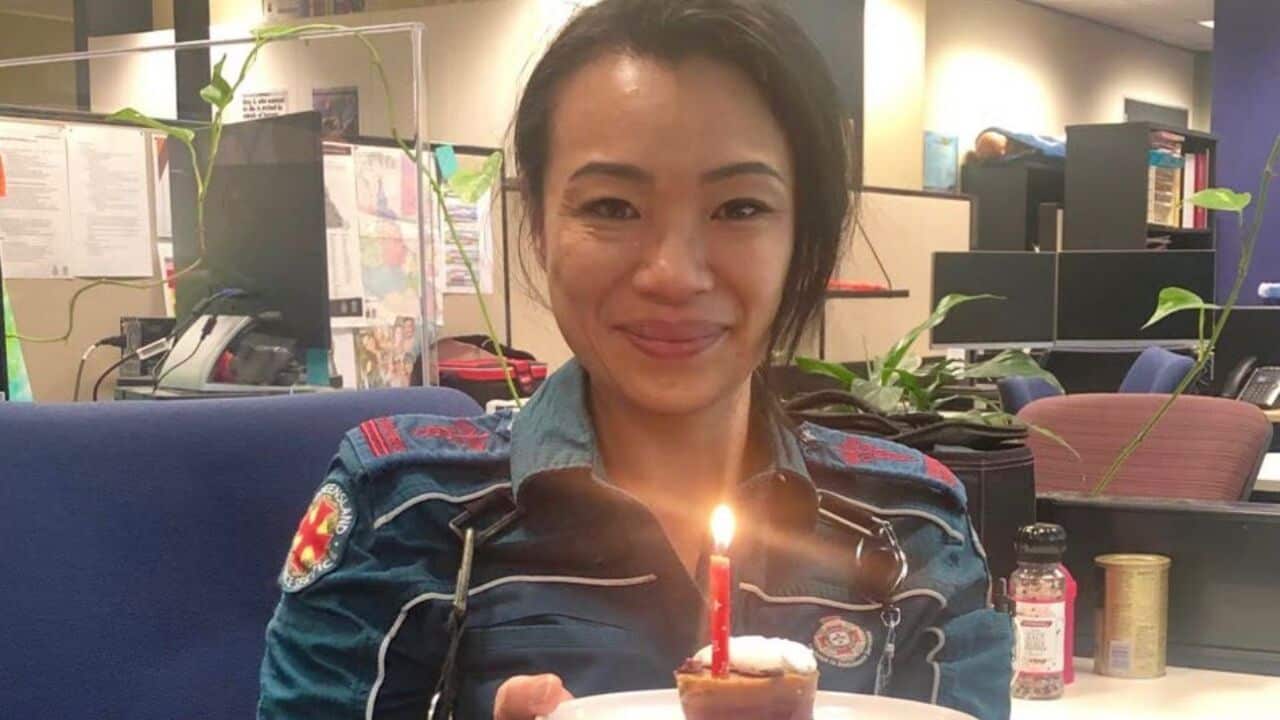 A woman in uniform holds a cake