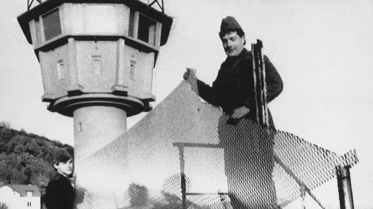 East German border guards remove a section of fence, Nov. 29, 1989 in front of a watch tower along the East-West German border at Phillipsthal.