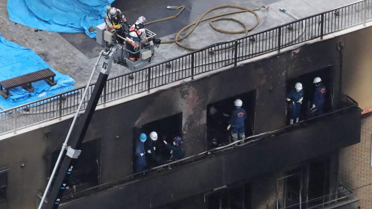 Kyoto police officers investigate at a three-story Kyoto Animation building, where a man set fire with liquid to kill 33 people and injure 35, in Kyoto.