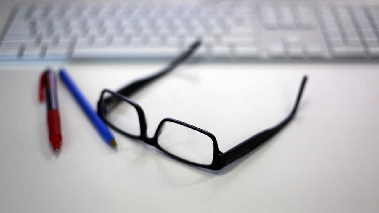 Reading glasses is featured alongside a Macintosh keyboard and office supplies in a stock image in Sydney, Wednesday, Jan. 13, 2016. (AAP Image/Sam Mooy) NO ARCHIVING