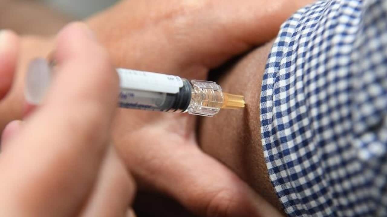 A man is seen receiving a flu immunisation