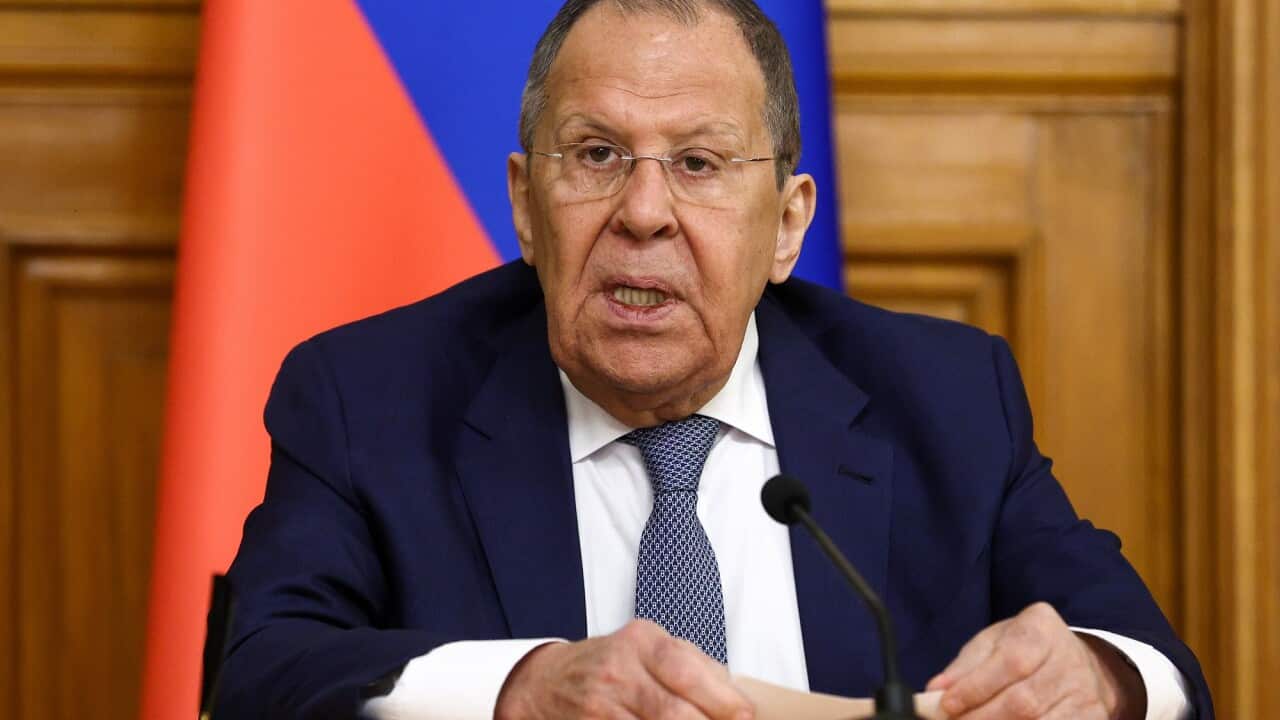 Russia's Foreign Minister Sergei Lavrov sits in front a microphone.