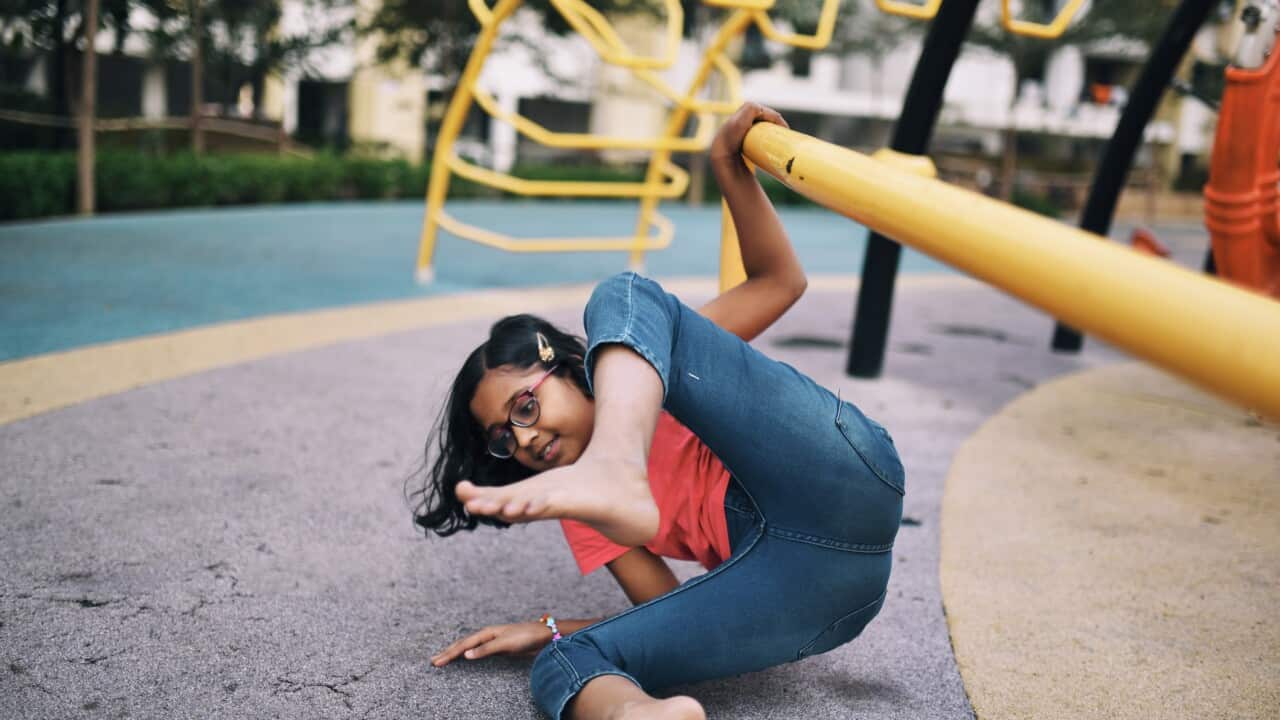 Girl falling down from the bar while playing in the jungle gym