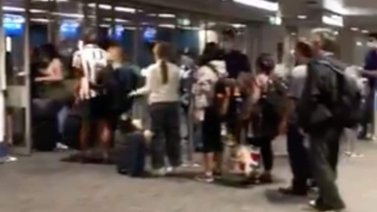 Returning overseas travellers line up in the arrivals area of Sydney Airport.