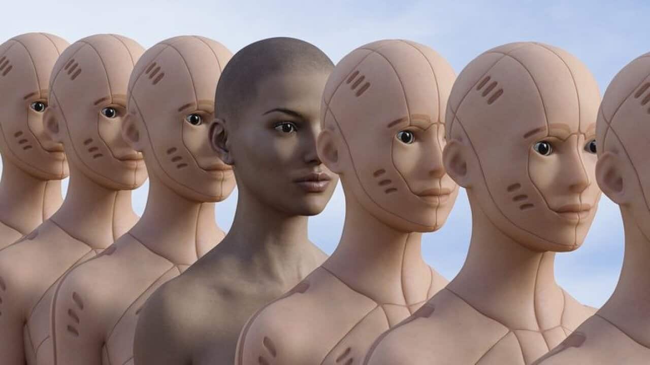 Woman standing in row of robots