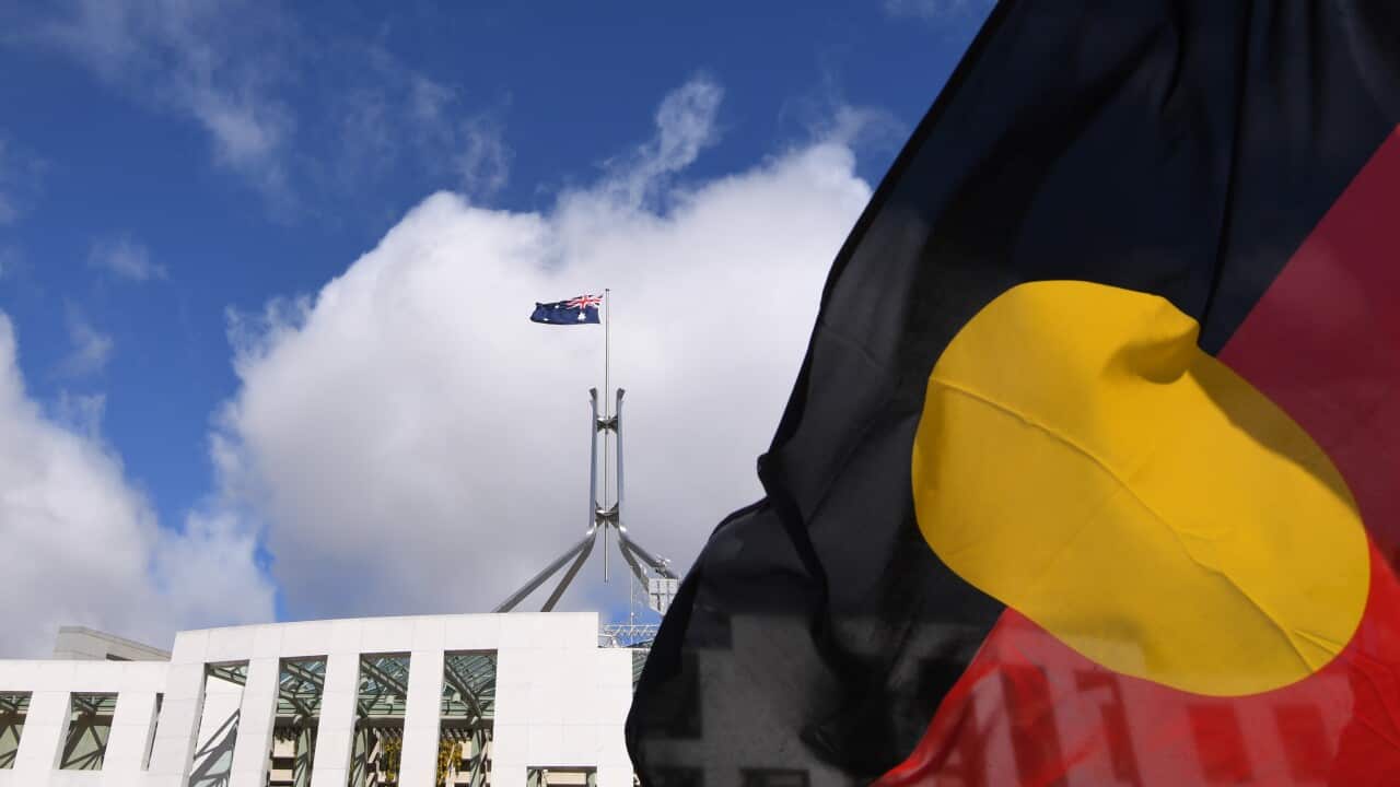 Australian Parliament House is seen through an Aboriginal flag in Canberra, Tuesday, September 5, 2017. (AAP Image/Lukas Coch) NO ARCHIVING
