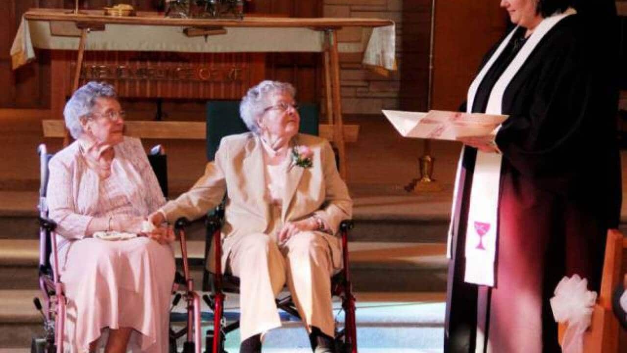 Reverend Linda Hunsaker presides over the wedding of Vivian Boyack, left, and Alice Dubes, center, in Davenport. (Thomas Geyer/AP)Reverend Linda Hunsaker presides over the wedding of Vivian Boyack, left, and Alice Dubes, centre, in Davenport, US. (Thomas