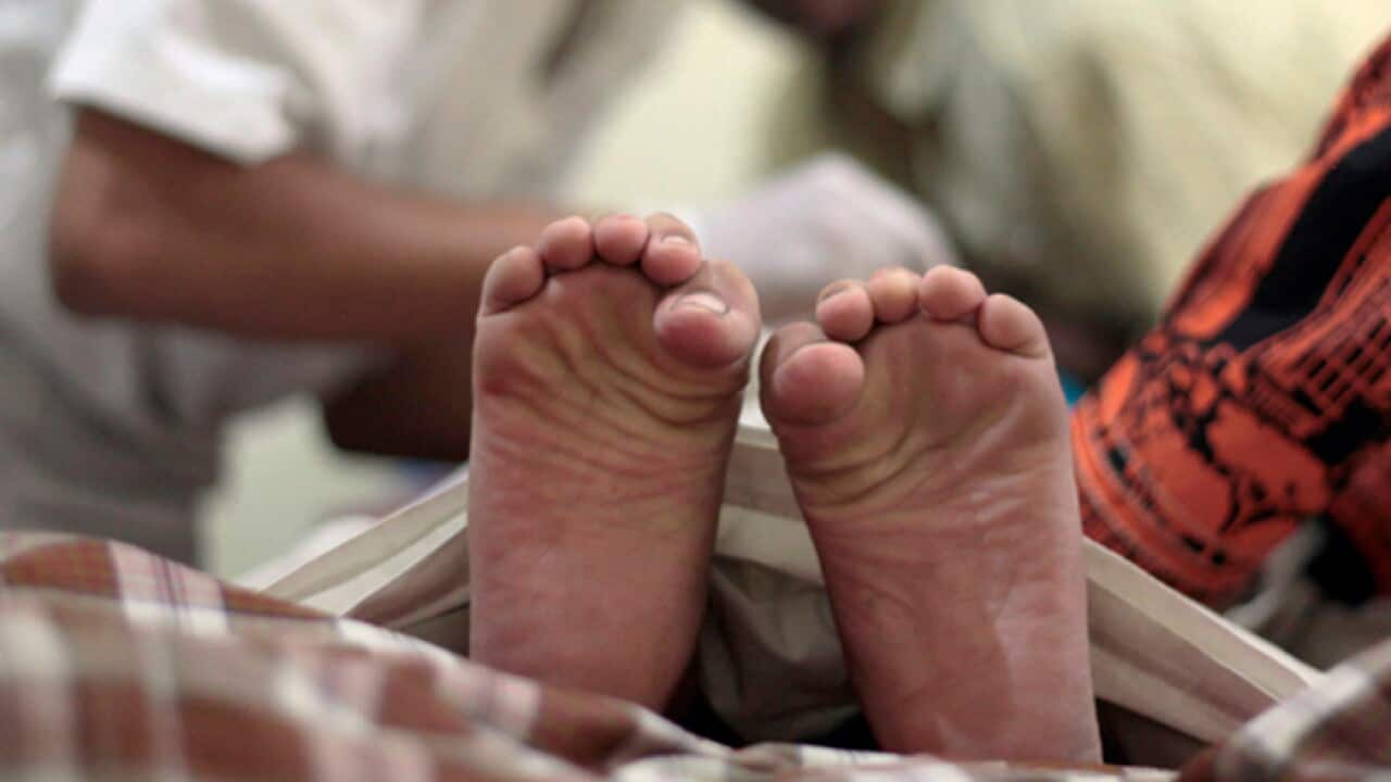 A boy's toes curl in pain as a doctor performs circumcision on him during a charge-free mass circumcision.