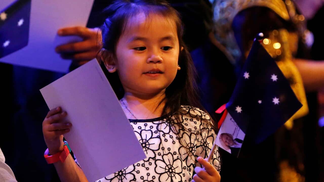 Four-year-old Bella Adlan receives her citizenship certificate and flag in Newcastle