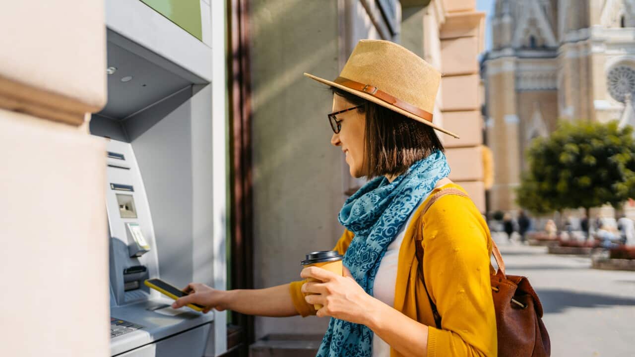 Young Woman Withdrawing Cash From The ATM