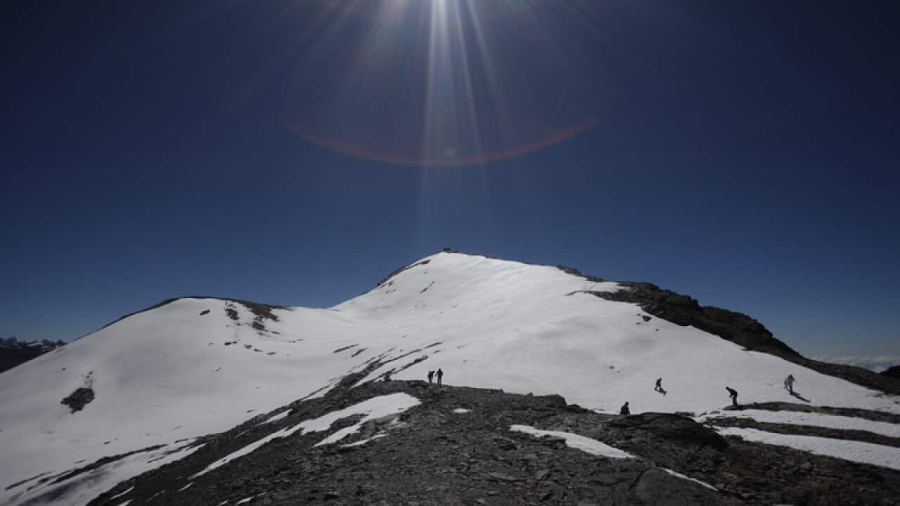 People walk along the Cordillera Real of the Andes mountains