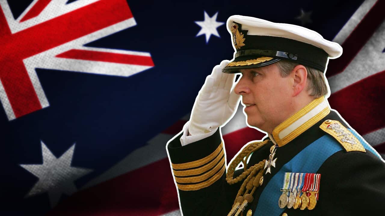 A man saluting an Australian flag, he wears a navy jacket decorated with medals.