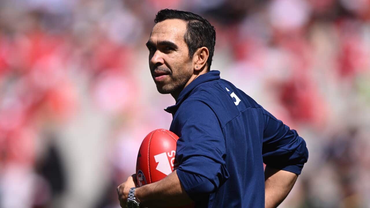 A man looks back while holding a football.