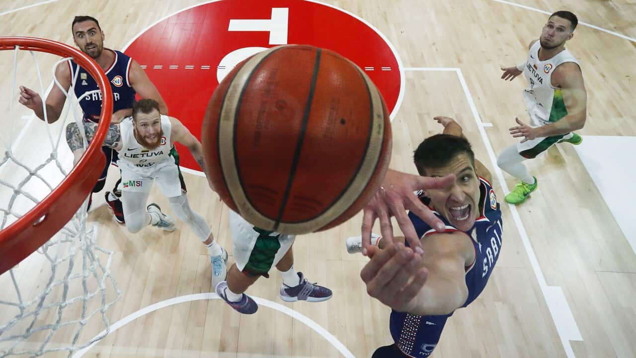 Bogdan Bogdanovic (C) of Serbia drives to the basket during the FIBA Basketball World Cup quarter final game between Lithuania and Serbia in Manila