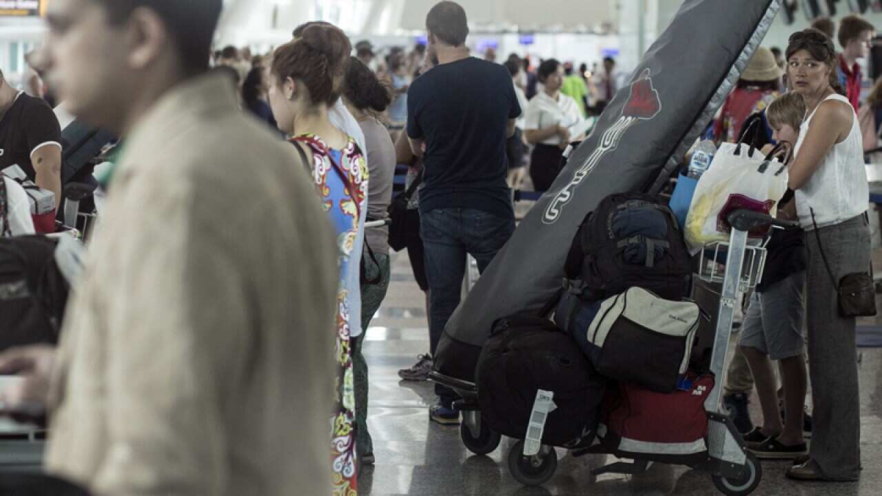 Passengers react to the re-opening of the Bali International Airport
