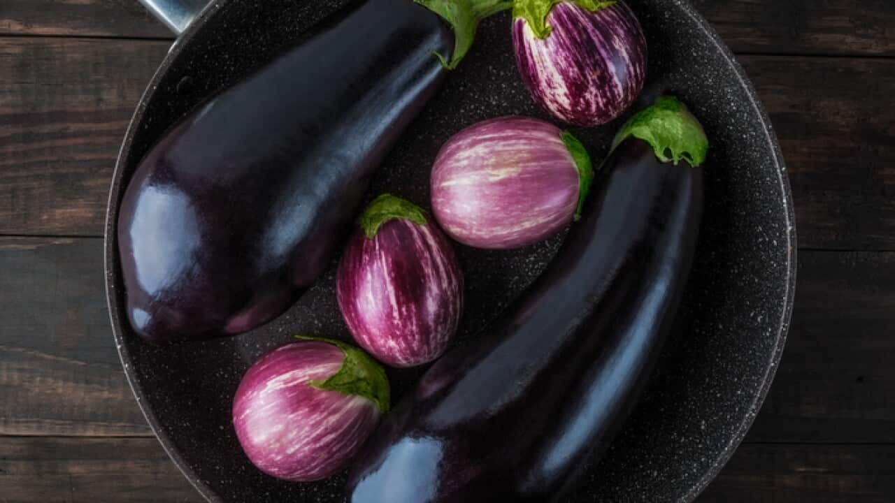 Whole eggplants on frying pan top view. 