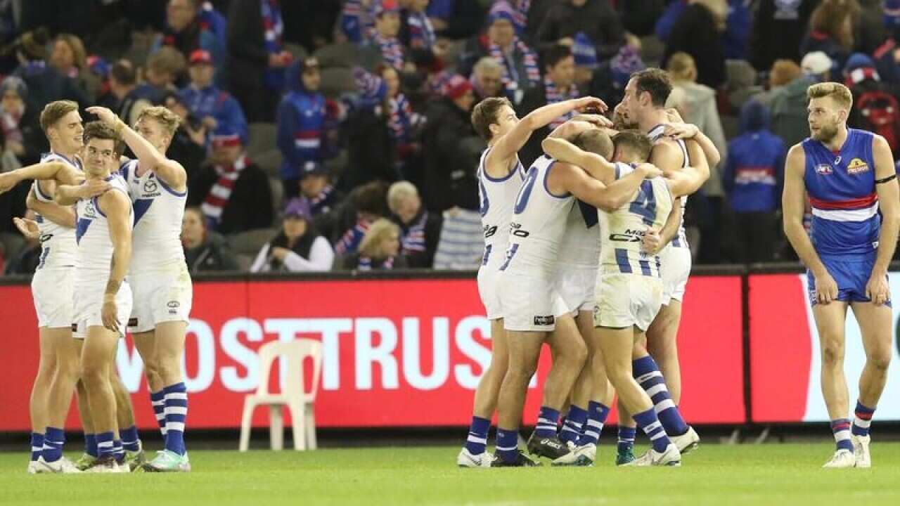North Melbourne players celebrate after the full-time siren