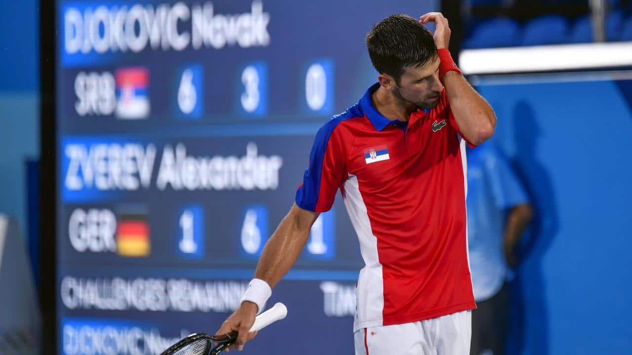 Serbia's Novak Djokovic wipes sweat from his face during his Tokyo Olympic singles semifinal match against Germany's Alexander Zverev at Ariake Tennis Park on July 30, 2021. (Kyodo via AP Images) ==Kyodo