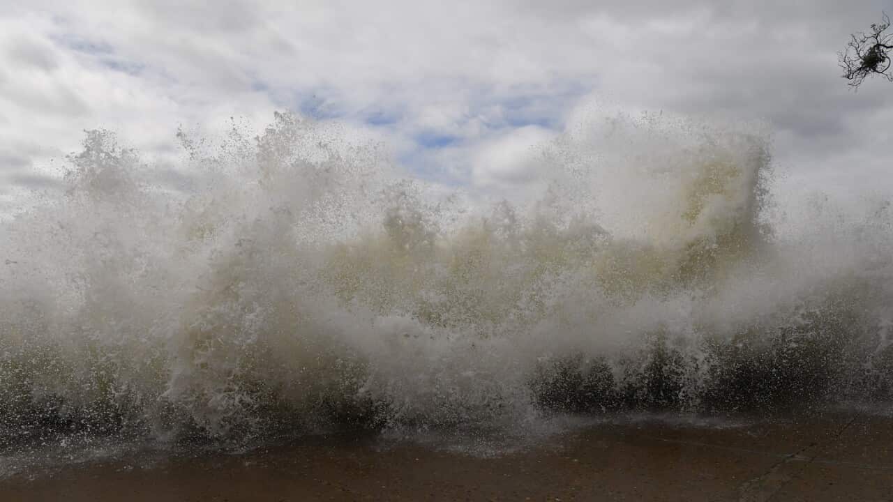 Onlookers watch as large waves pound the promenade and ocean baths at Bronte Beach in Sydney, Saturday, April 2, 2022