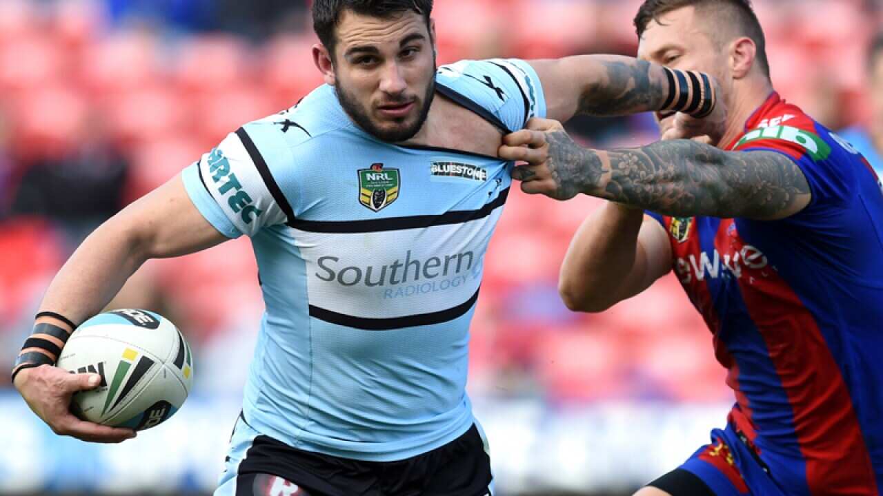 Jack Bird of the Sharks fends off Tariq Sims of the Knights.