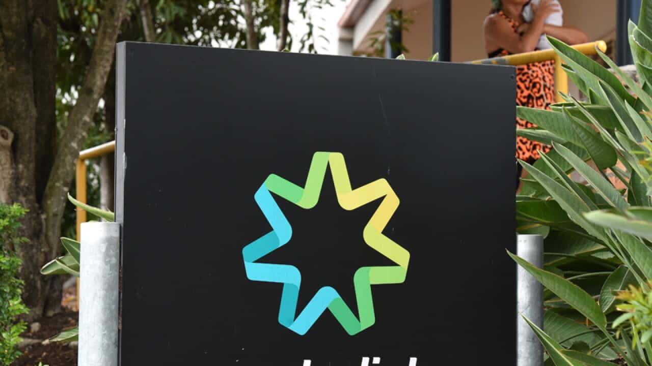 A woman nurses a baby outside a Centrelink office