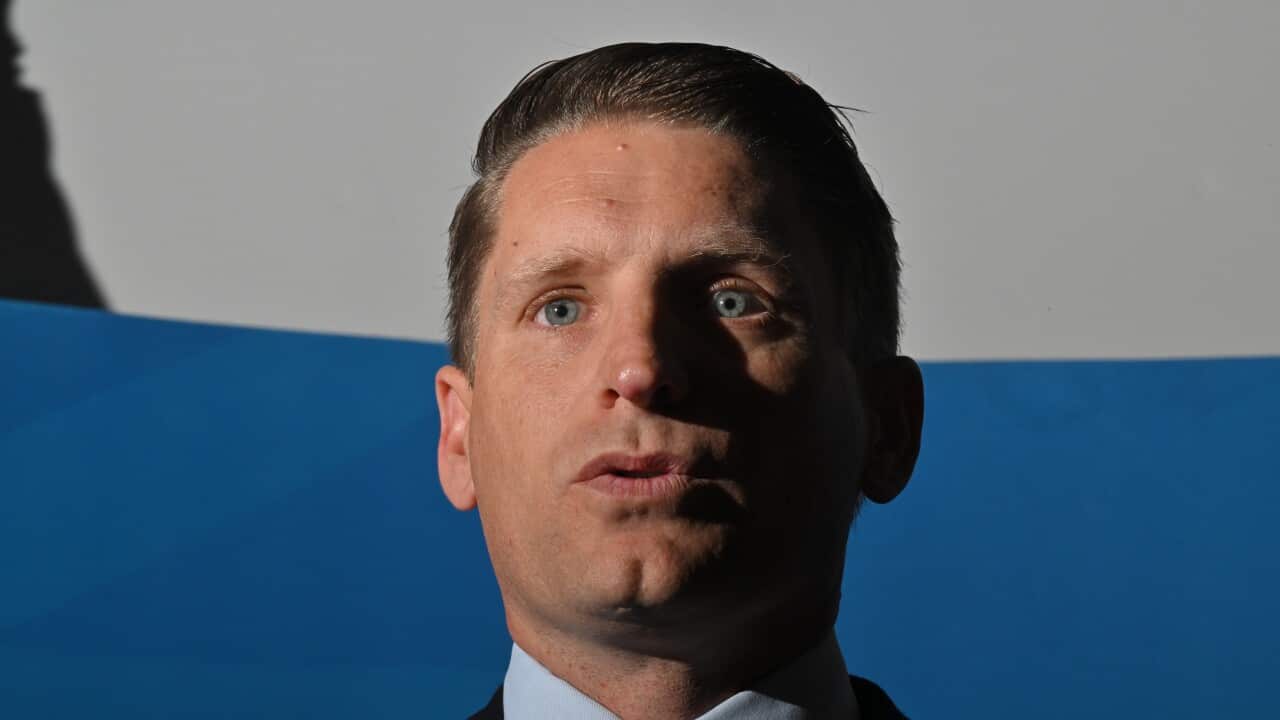 A close up of a white man wearing a suit
