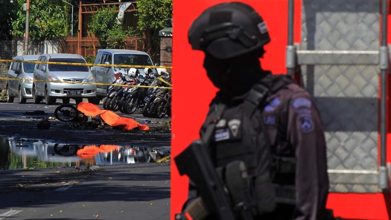 An Indonesian anti-terror policeman stands guard at the blast site following a suicide bomb outside a church in Surabaya.