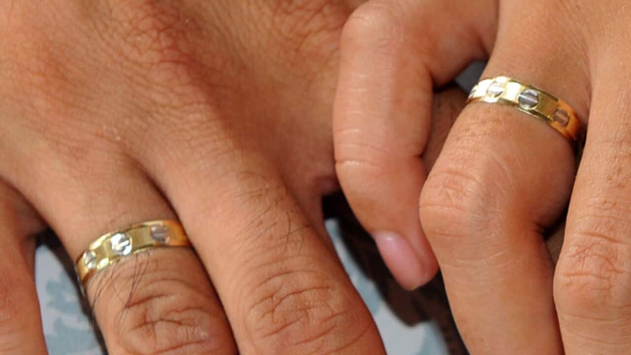 A couple holds hands showing their weddi