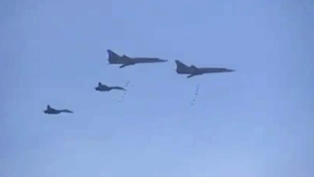 In this photo made from the footage taken from Russian Defense Ministry official web site on Tuesday, Nov. 17, 2015, Russian Tu-22 bombers escorted by the Su-27s fighter jets drop bombs on a target in Syria. (AP Photo/ Russian Defense Ministry Press Servi