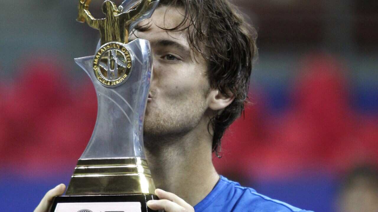Joao Sousa of Portugal kisses his trophy at the Malaysian Open