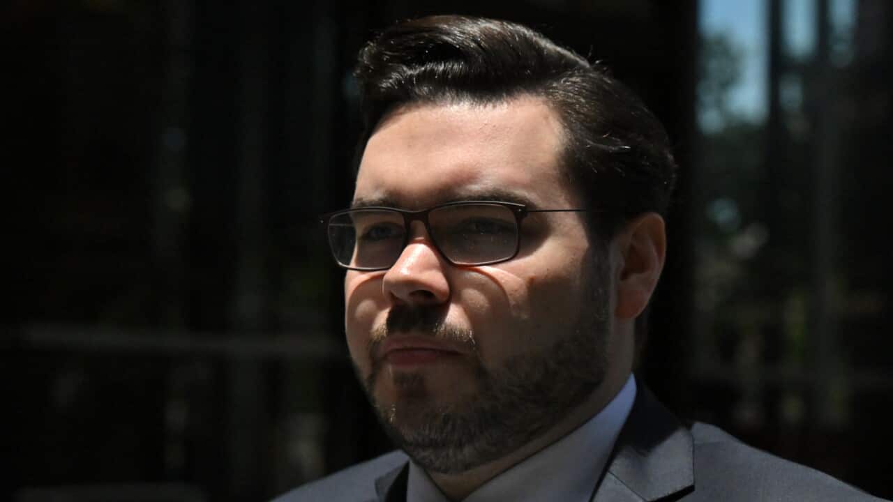 A close up of a man wearing glasses and a suit