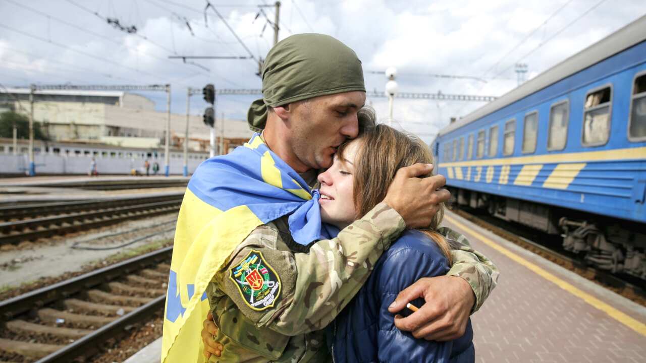 A discharged Ukrainian serviceman kisses his girlfriend on a platform of Kiev railway station as he arrived in the capital after one year fighting.
