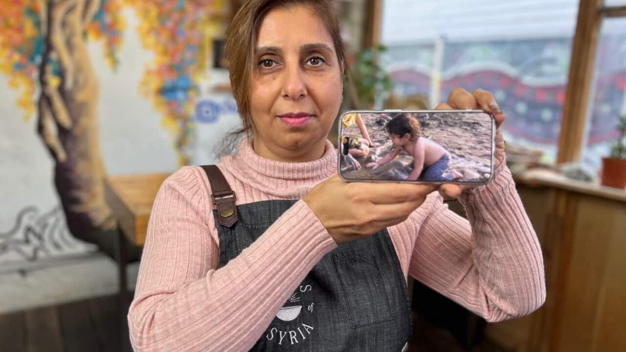 Nayran Tabiei with a photo of her young son, who has fled Tehran with his brothers (SBS Scott Cardwell).jpg
